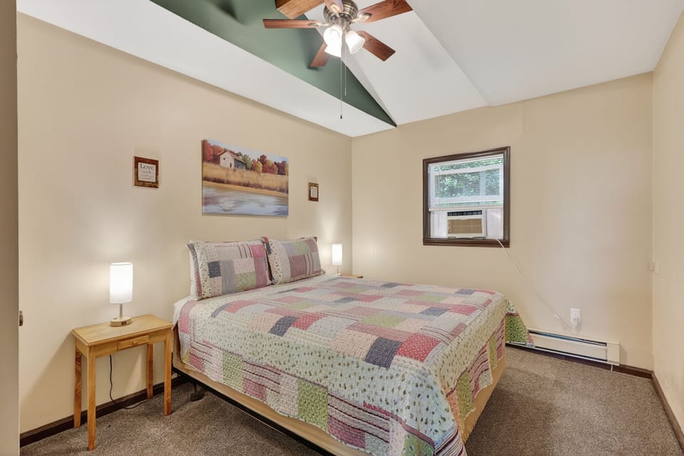 Cozy queen bedroom with USB lamps, A/C, and ceiling fan for a restful stay.