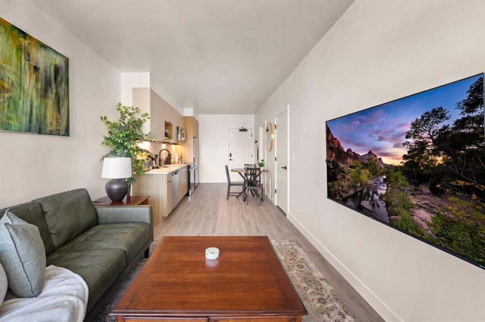 Beautifully designed living room. 60` TV, leather sofa and amazing views of mountains and city skyline