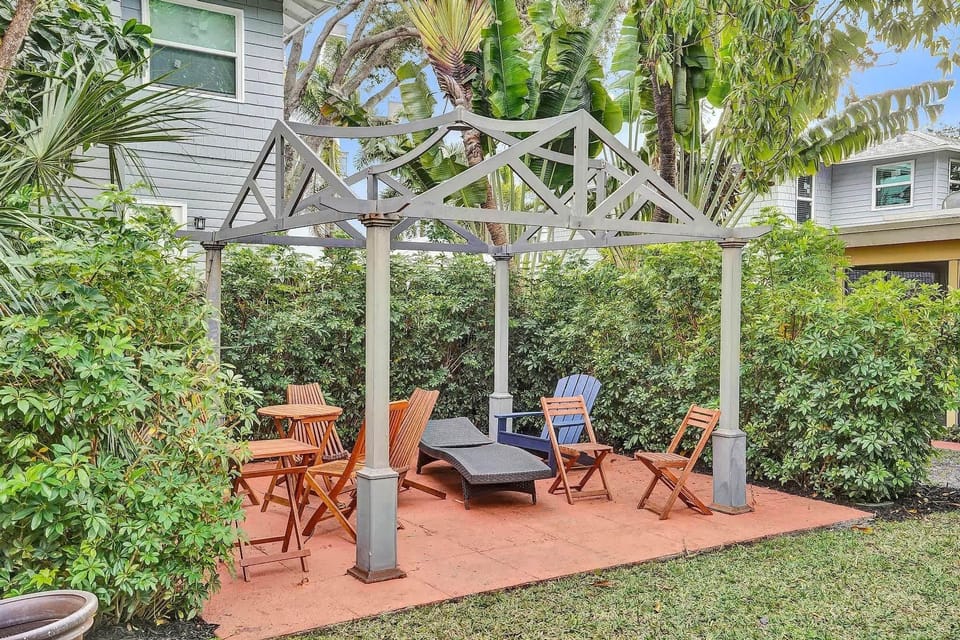 Shaded pergola with lounge chairs and garden