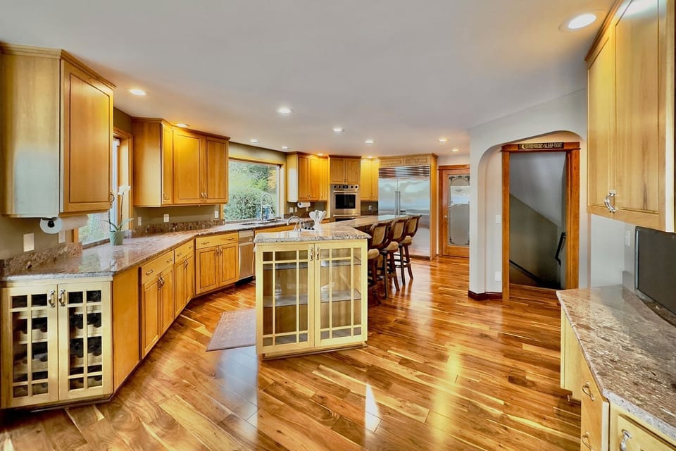 Modern kitchen with granite counters, Sub-Zero appliances, island, and pantry
