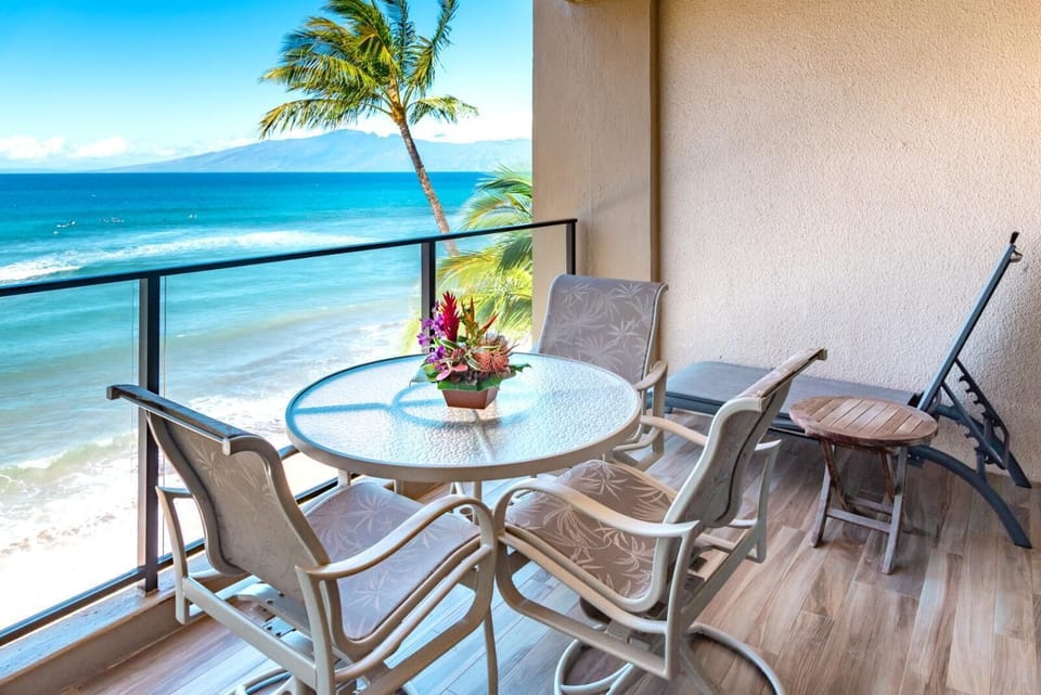 A glass-top table cradles fresh island blooms while waves applaud your every breath from the comfort of your seat MAH-419
