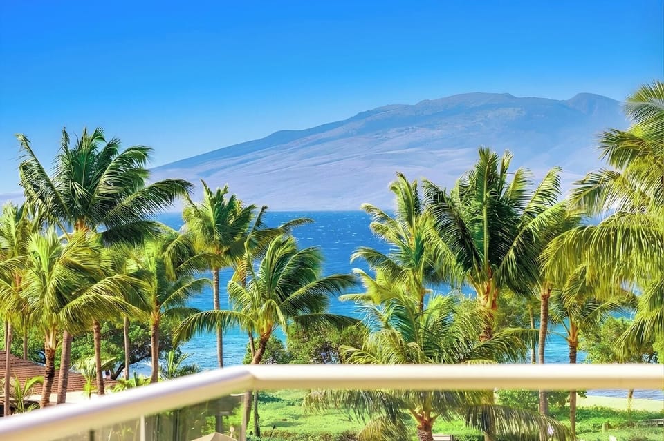 A peaceful island scene stretches out from your balcony with tropical gardens, resort pools, and ocean horizon. HKK-439