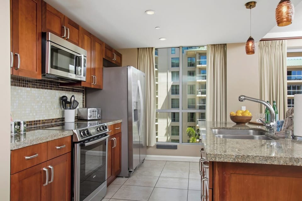 Sunlit modern kitchen with granite counters, stainless appliances, and charm. HKK-539