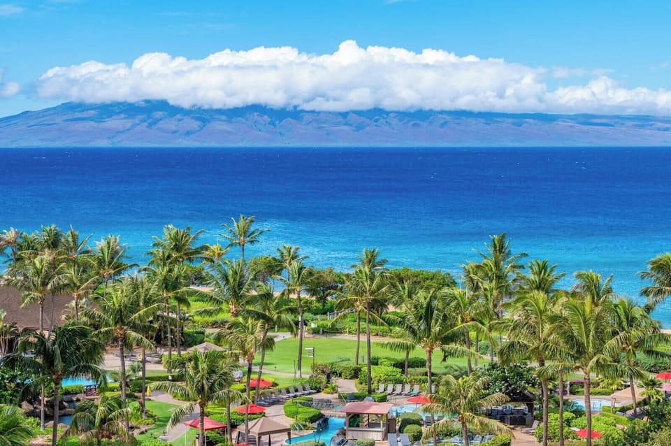 Unmatched ocean views and lush resort landscaping define the Honua Kai experience, with the island of Molokai rising across the vibrant blue channel. HKK-829