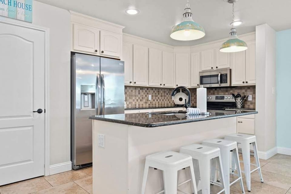 Fully equipped kitchen with breakfast bar—perfect for gathering and dining.
