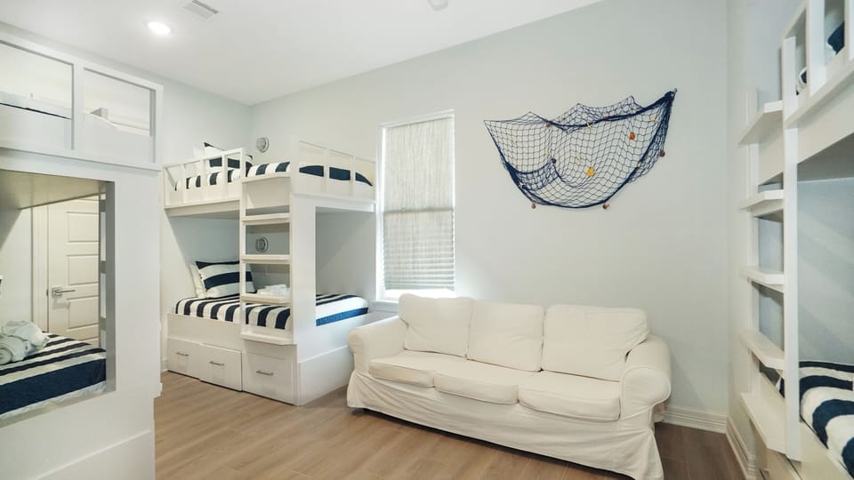 Family bunk room with built-in bunk beds and seating area, ideal for kids and large family groups visiting Galveston.
