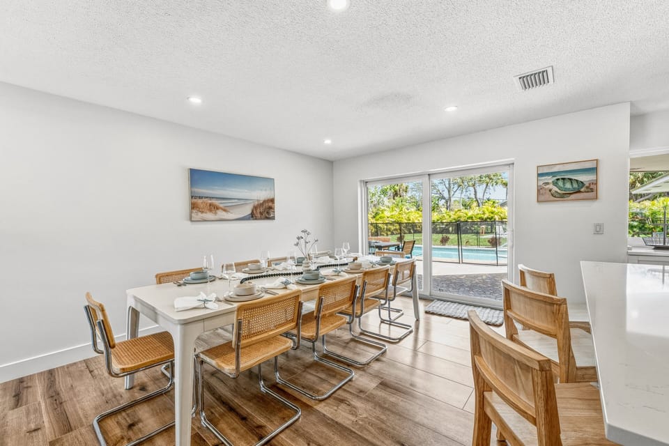 The dining area opens directly to the backyard and pool for easy indoor-outdoor living.