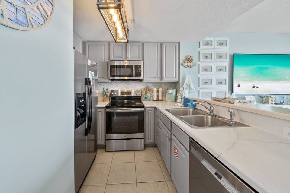 Fully equipped kitchen with stainless steel appliances, dishwasher, and generous counter space — everything you need to cook and clean up with ease.