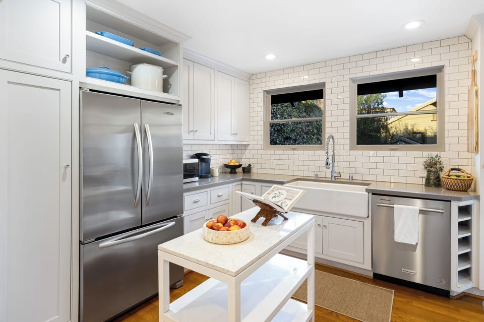 Light-filled kitchen with a farmhouse sink, stainless steel appliances, and clean modern finishes.