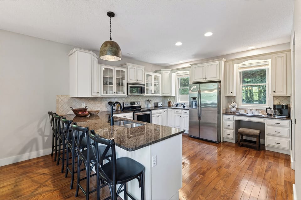 Spacious chef’s kitchen with granite island, bar seating, and stainless steel appliances—perfect for gathering and entertaining.