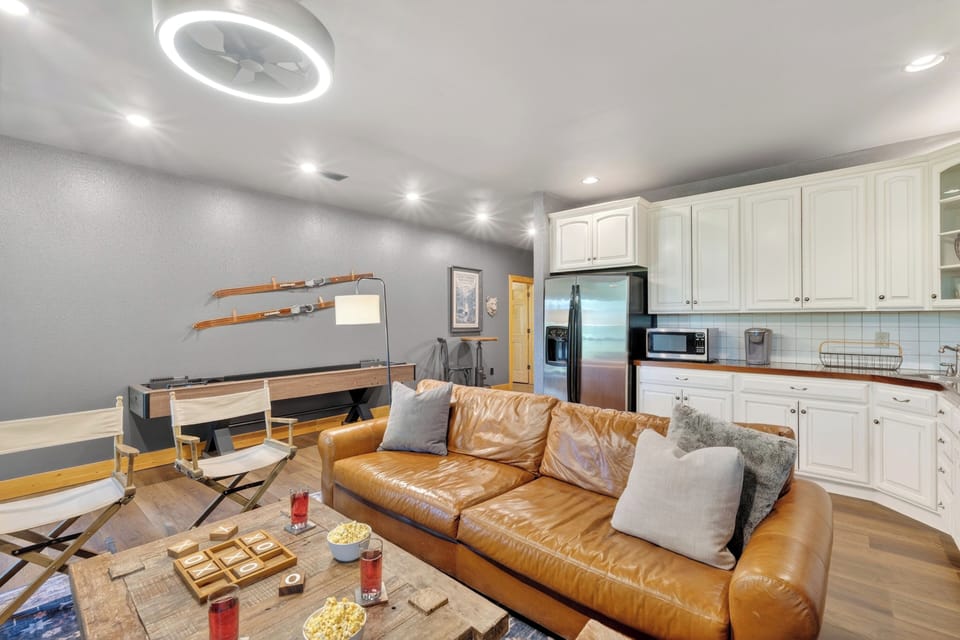 Cozy secondary living room with fireplace, large TV, and game-ready setup for movie nights or friendly competition.