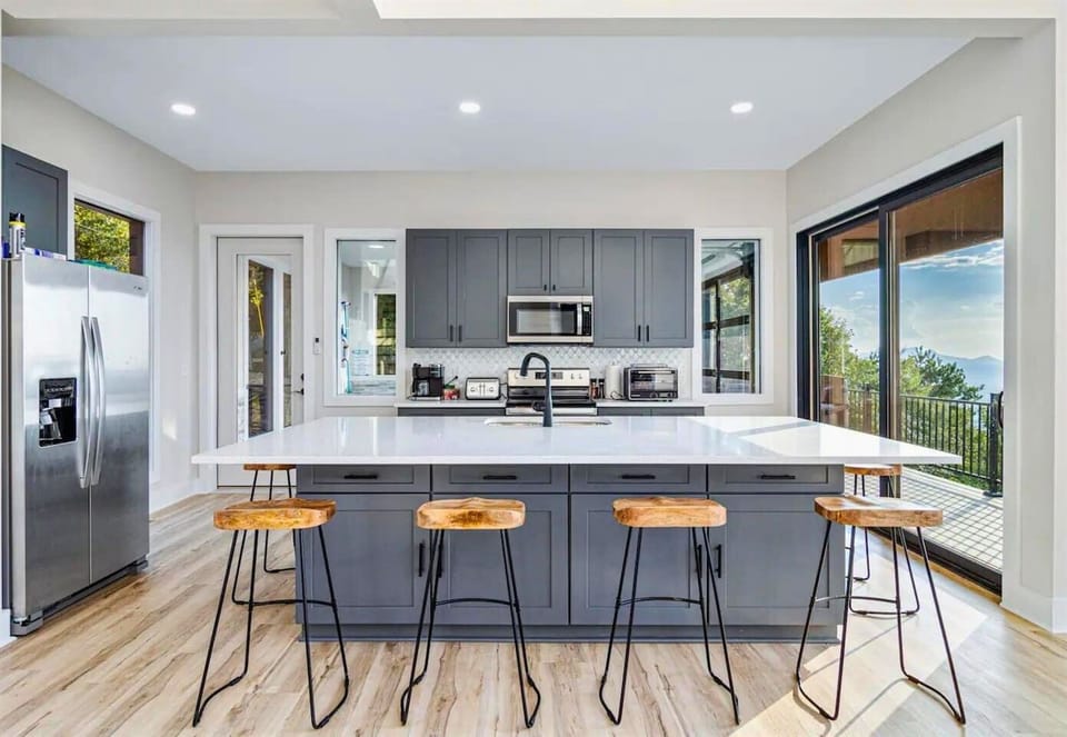 A modern seating arrangement surrounds the spacious kitchen island, ideal for casual dining or quick snacks.