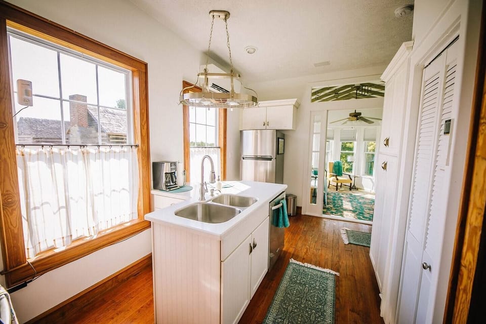 Offers an open layout with a large island sink, and warm wood flooring that leads directly into the sun-drenched living area