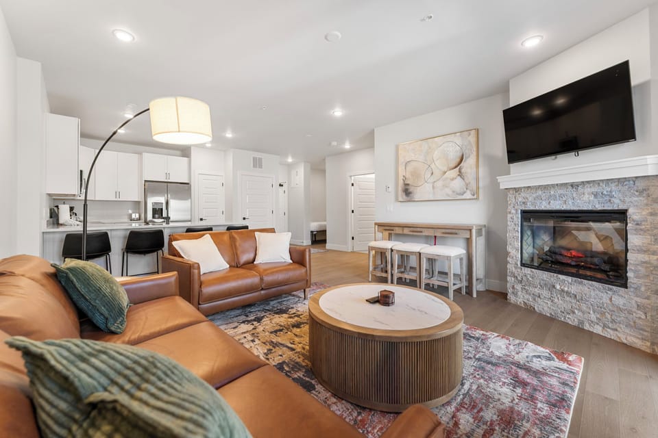 Picture yourself unwinding on plush leather sofas, gathering around the warm fireplace, or enjoying your favorite shows on the wall-mounted TV.