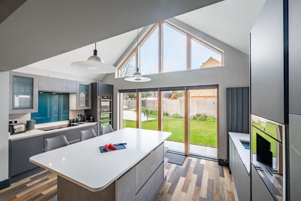 Ground floor: Kitchen with an electric oven and induction hob, microwave, dishwasher, fridge-freezer, Nespresso Pixi coffee machine, sit-up island for three and double doors to the patio and garden