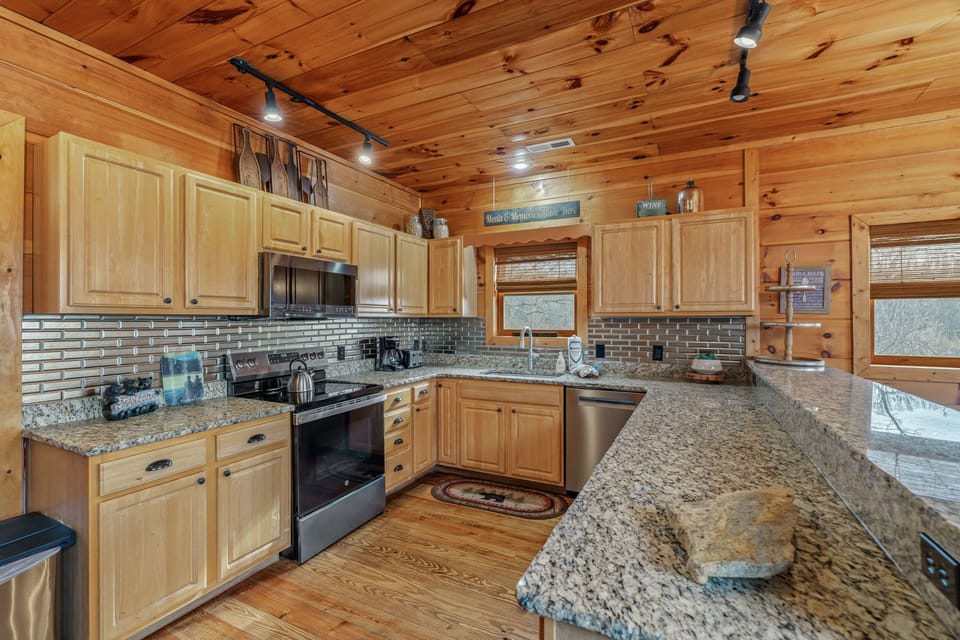 Your fully equipped rustic kitchen features granite counters, modern appliances, and charming wood details perfect for preparing mountain meals.