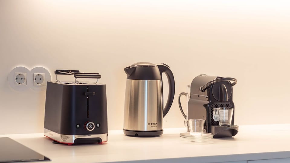 A close-up of the kitchen essentials: toaster, kettle, and coffee machine. Practical and sleek, all you need to enjoy your mornings. #KitchenEssentials #MorningBrew