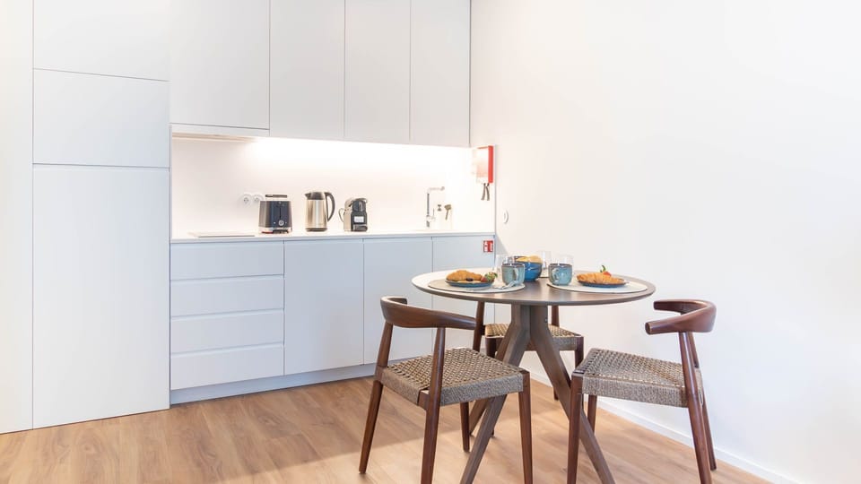 A modern kitchenette with a dining space, perfect for enjoying meals. The sleek appliances and neutral tones offer a clean, functional space. #HomeStyle #CozyDining