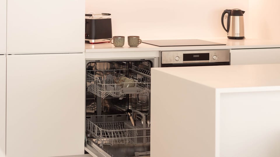 Fully equipped kitchen with a dishwasher and coffee essentials, ready for your convenience. #ConvenientLiving #FunctionalDesign