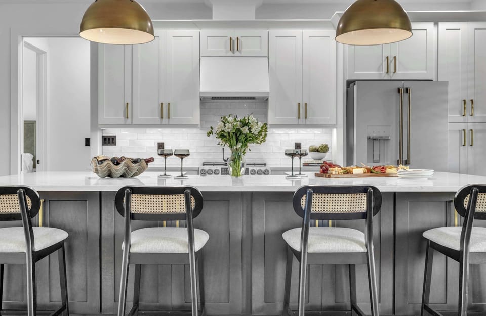 Large island with bar seating, pendant lighting, and sleek cabinetry—perfect for meals or cocktails.