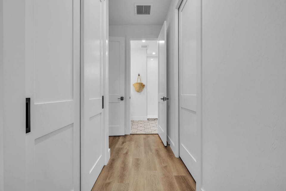 Clean, modern hallway with warm wood flooring and a bright, airy feel throughout the home.