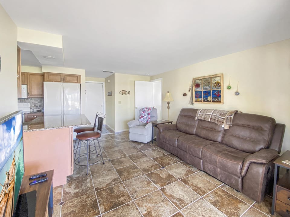 Cozy living area with plush seating and open kitchen, perfect for relaxing and entertaining.