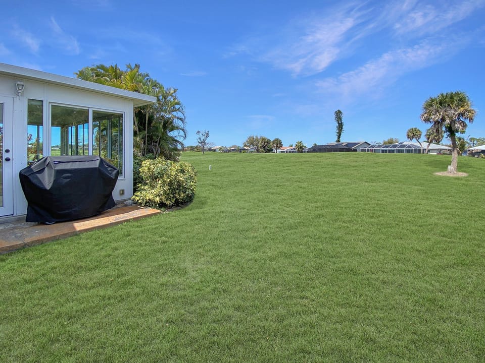 Expansive backyard with a covered grill area, perfect for outdoor gatherings and barbecues.