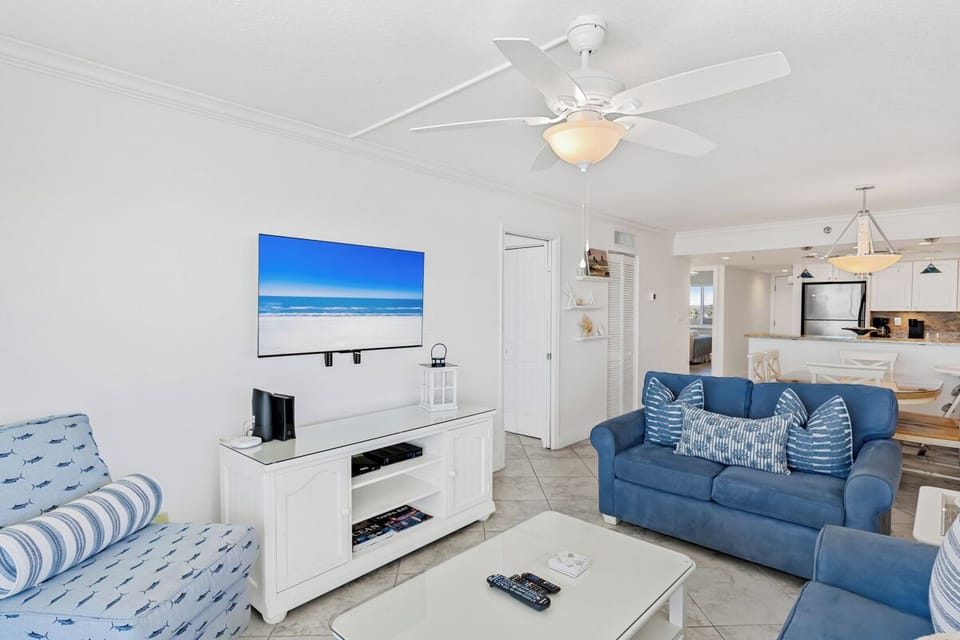 Unwind in your coastal-inspired living room with ocean blues, cozy seating, and entertainment center ready for relaxing evenings.
