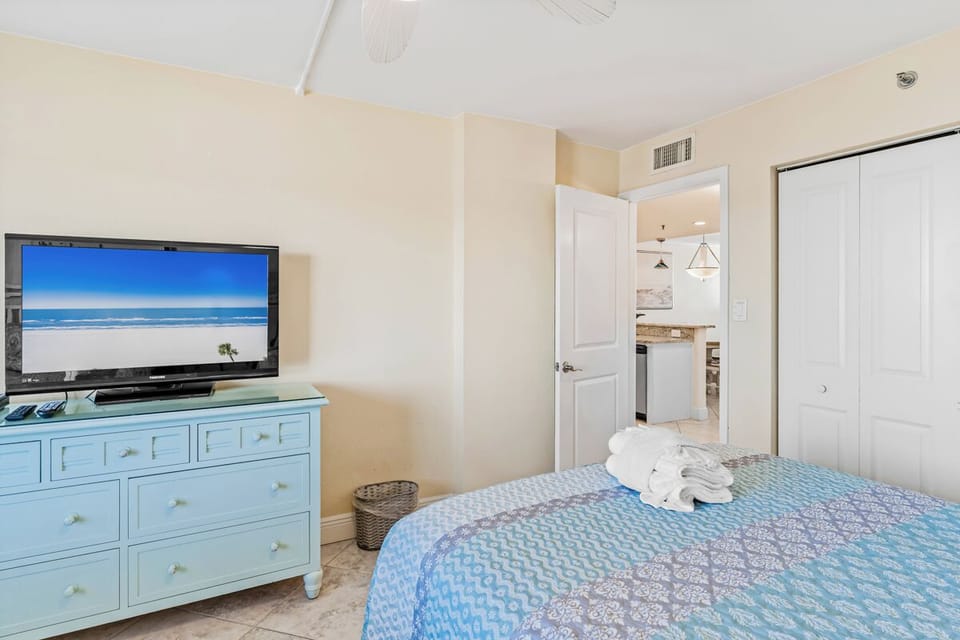 Your peaceful bedroom features coastal-blue furnishings, flat-screen TV, and air conditioning for ultimate comfort after beach days.