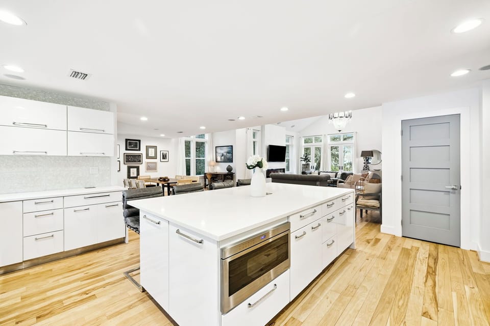 Your gourmet kitchen features pristine white cabinetry, marble countertops, and a spacious island perfect for cooking adventures.