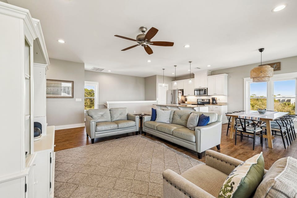 Relax in your spacious open-concept living area with plush seating, modern kitchen, and natural light streaming through large windows.