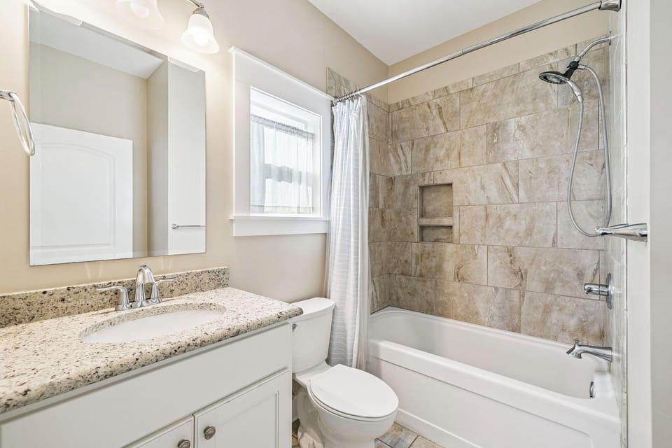 Step into your elegant bathroom featuring granite countertops, marble-style tiling, and a luxurious tub-shower combo for relaxing after your adventures.