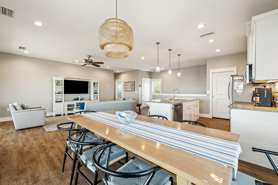 Your open-concept space flows seamlessly from dining to living to kitchen, perfect for gathering with loved ones under warm pendant lighting.