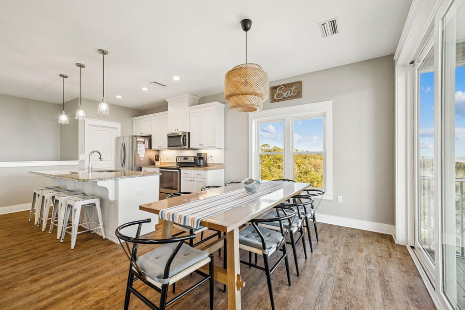 Gather around your spacious dining table while meals simmer in the fully-equipped kitchen, with natural light streaming through windows.
