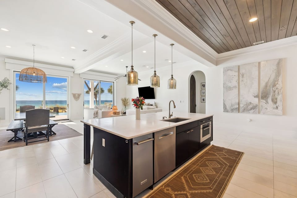 Your gourmet kitchen flows seamlessly into the living area, where stunning ocean views through floor-to-ceiling windows create the perfect backdrop for cooking and entertaining.