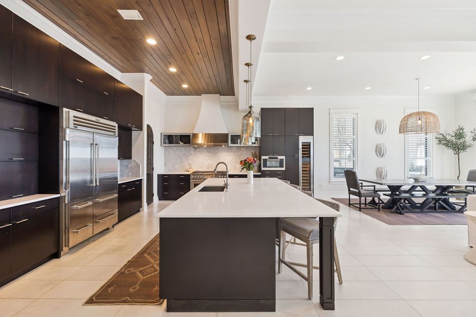Your gourmet kitchen awaits with sleek dark cabinetry, marble countertops, and top-tier stainless steel appliances for unforgettable culinary moments.