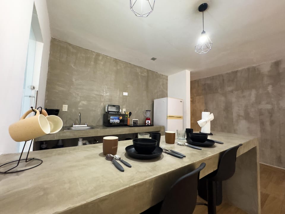 Sleek modern kitchen with concrete countertops and cozy seating
