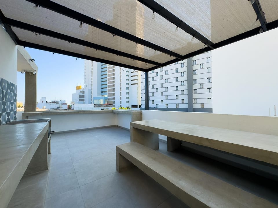 Spacious rooftop patio with shaded seating and city views