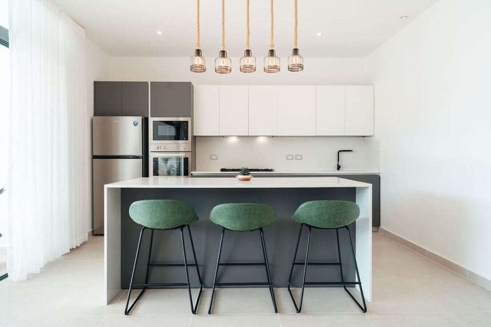 Bright, modern kitchen with a spacious island—perfect for quick meals, coffee, or a casual hangout. Fully equipped with everything you need, just steps from the balcony.