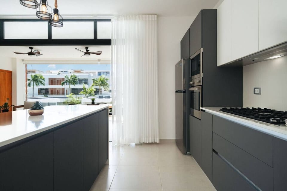 Sleek, fully equipped kitchen with plenty of counter space and a large island. Bright and airy, with sliding doors that open out to the balcony for a nice breeze while you cook.