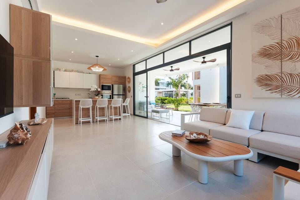 Bright open living space with a fully equipped kitchen, bar seating, and large sliding doors that open to the patio—great for relaxing or keeping an eye on the outdoor area.