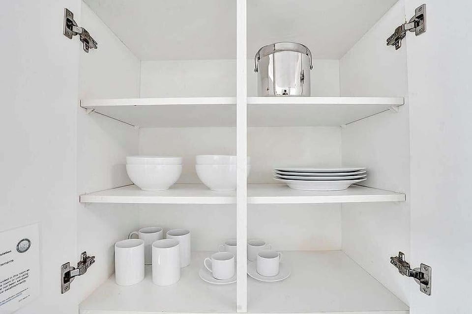 Kitchen cabinets stocked with dishes and mugs