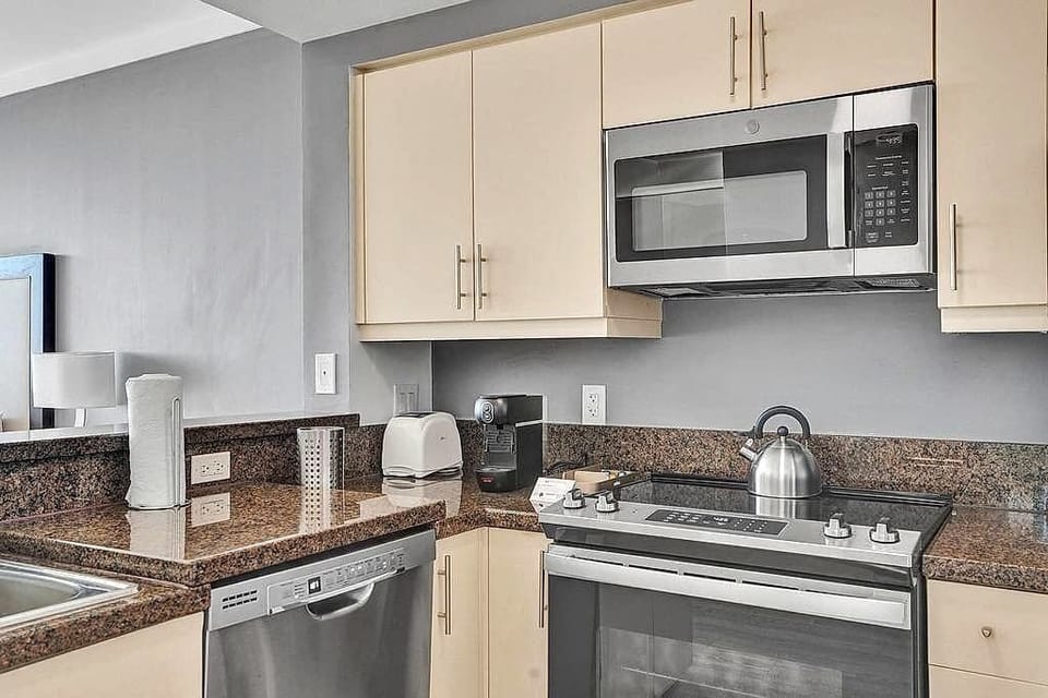 Kitchen cooktop area with microwave and appliances