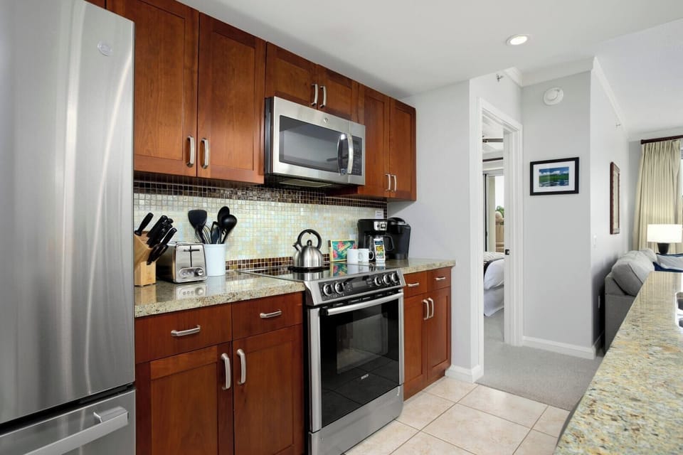 Modern kitchen with stainless appliances and warm wood cabinetry throughout. HKK-220