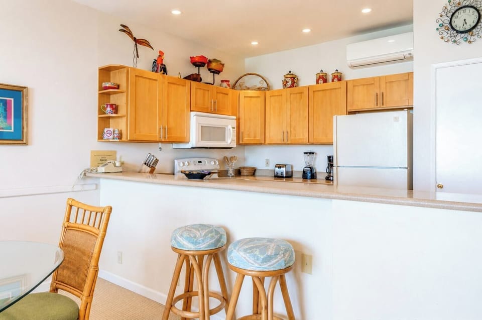 Fully equipped kitchen featuring a breakfast bar with seating—perfect for a quick morning bite before hitting the beach. NAP-B43