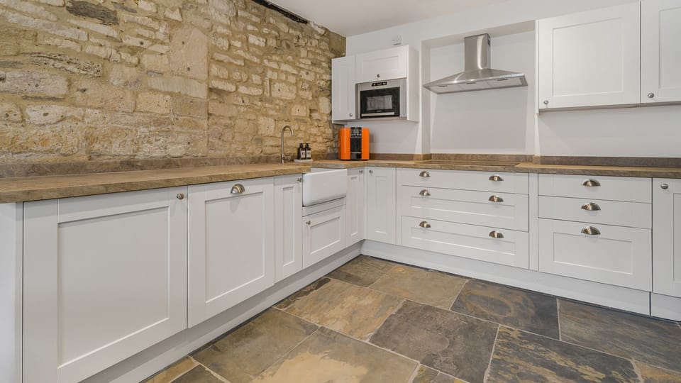 The fully appointed kitchen incorporates original stone walls, with a modern country feel.