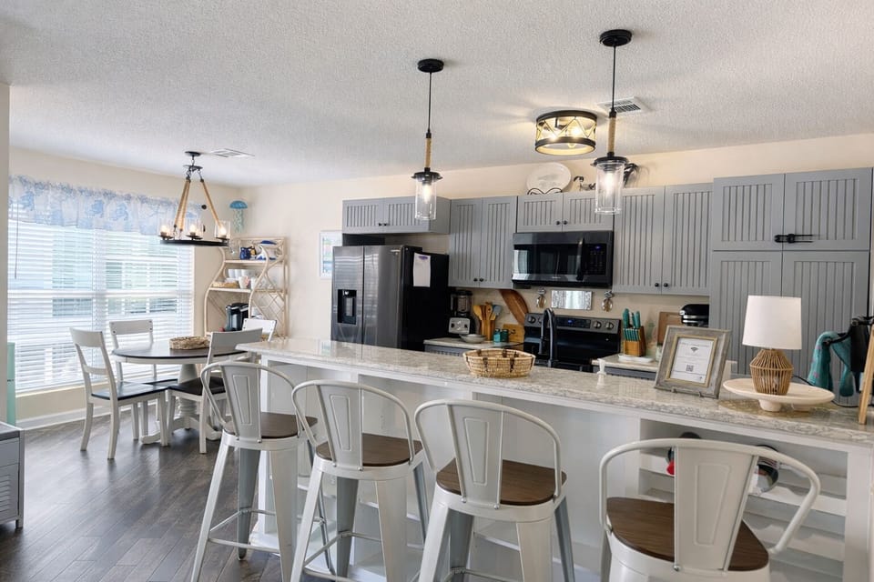 Bright coastal kitchen with modern appliances, microwave, and everything needed 