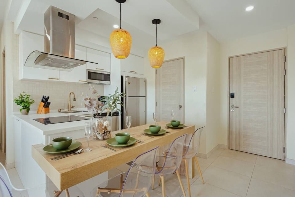 Dining table set for four beside the fully equipped kitchen — great for shared meals, coffee mornings, or takeout nights after the beach.