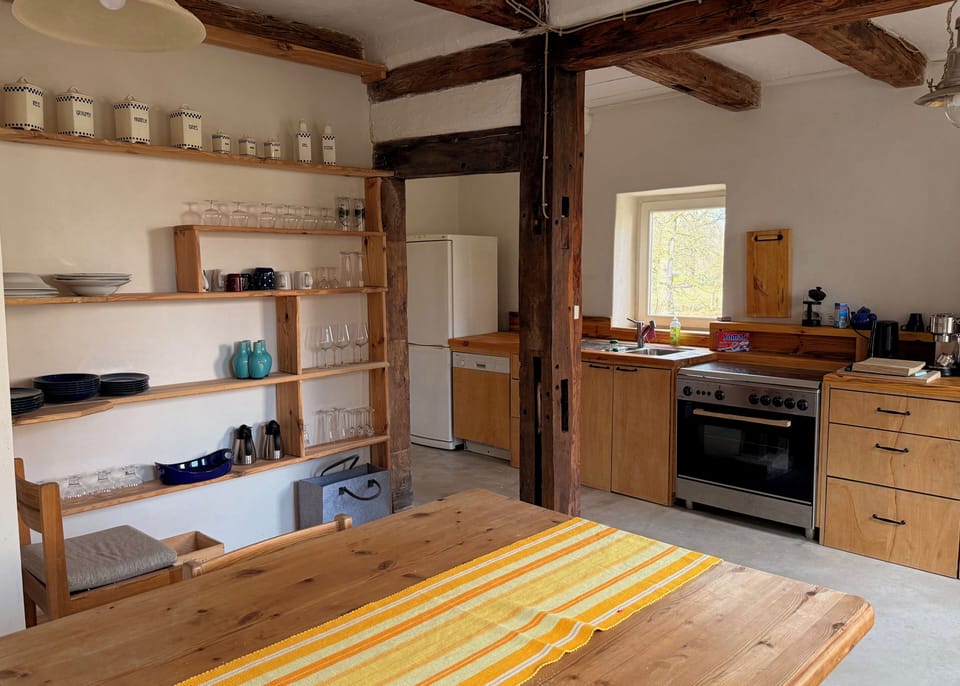 kitchen with a large table, a 5 filed gas stove and coffee/tea accessories. 