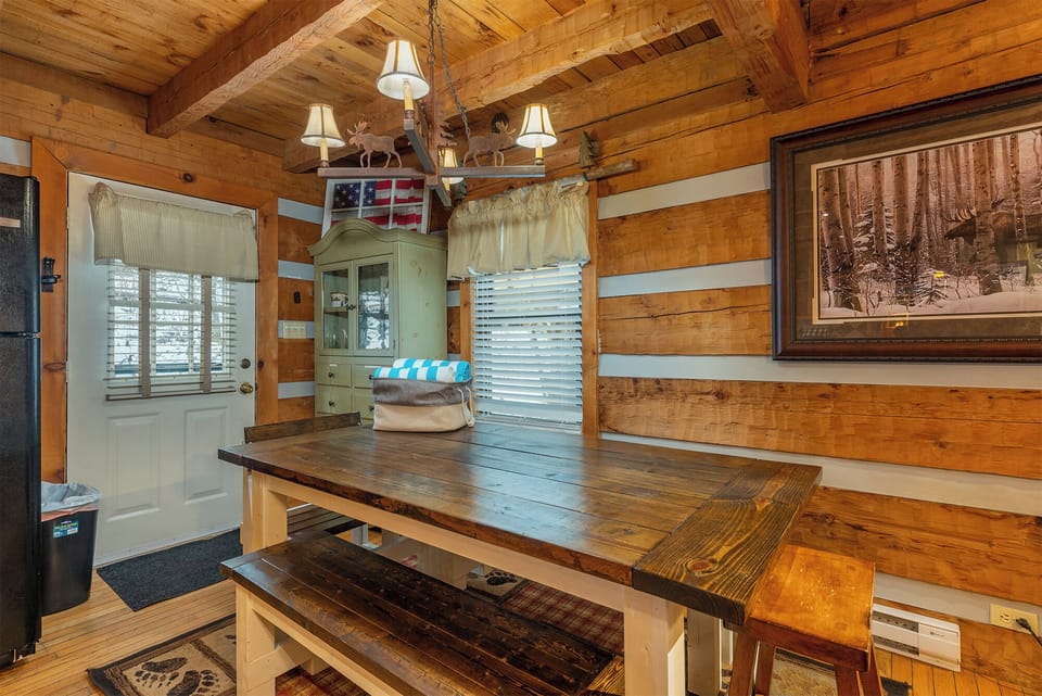 Rustic dining area with solid wood table and cabin-style details. A cozy space to gather and share meals.